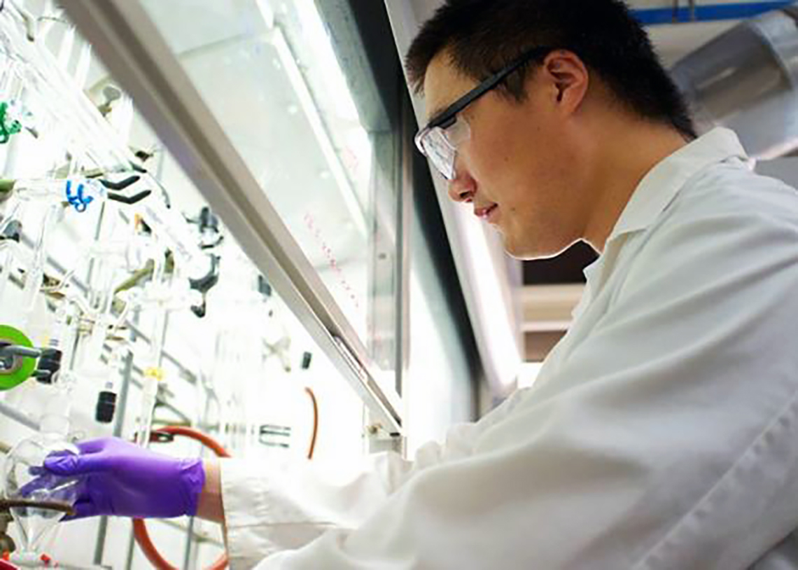 chemist working in a laboratory safety cabinet